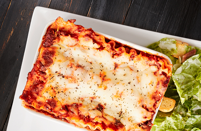 Lasagna layered with mozzarella, seasoned meat sauce and vegetables
