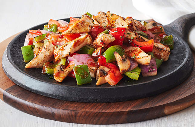 Chicken skillet with peppers, red onions, tomatoes, mushrooms and garlic spread