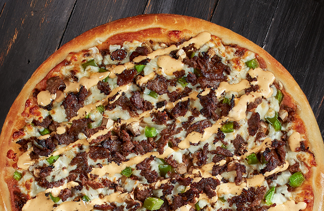 Steakhouse pizza with steak, peppers, onions, mushrooms, mozzarella, BBQ sauce and chipotle mayo