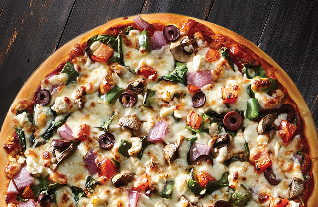 Greek vegetable pizza with spinach, mushrooms, peppers, tomatoes, olives, mozzarella and feta